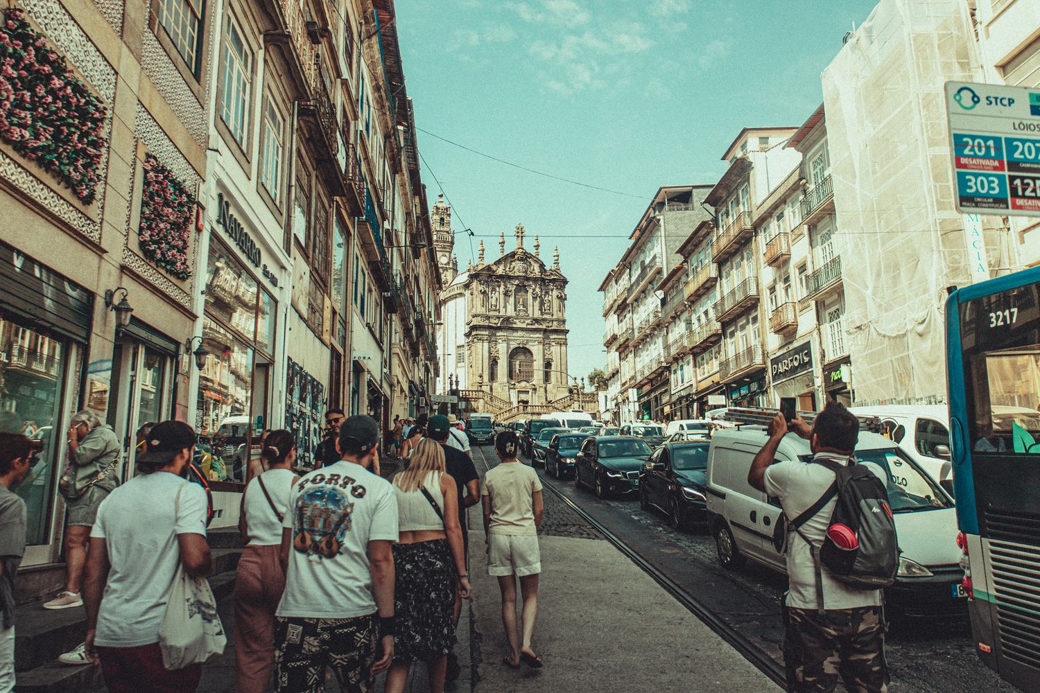 Rua movimentada do Porto com peões e arquitetura histórica