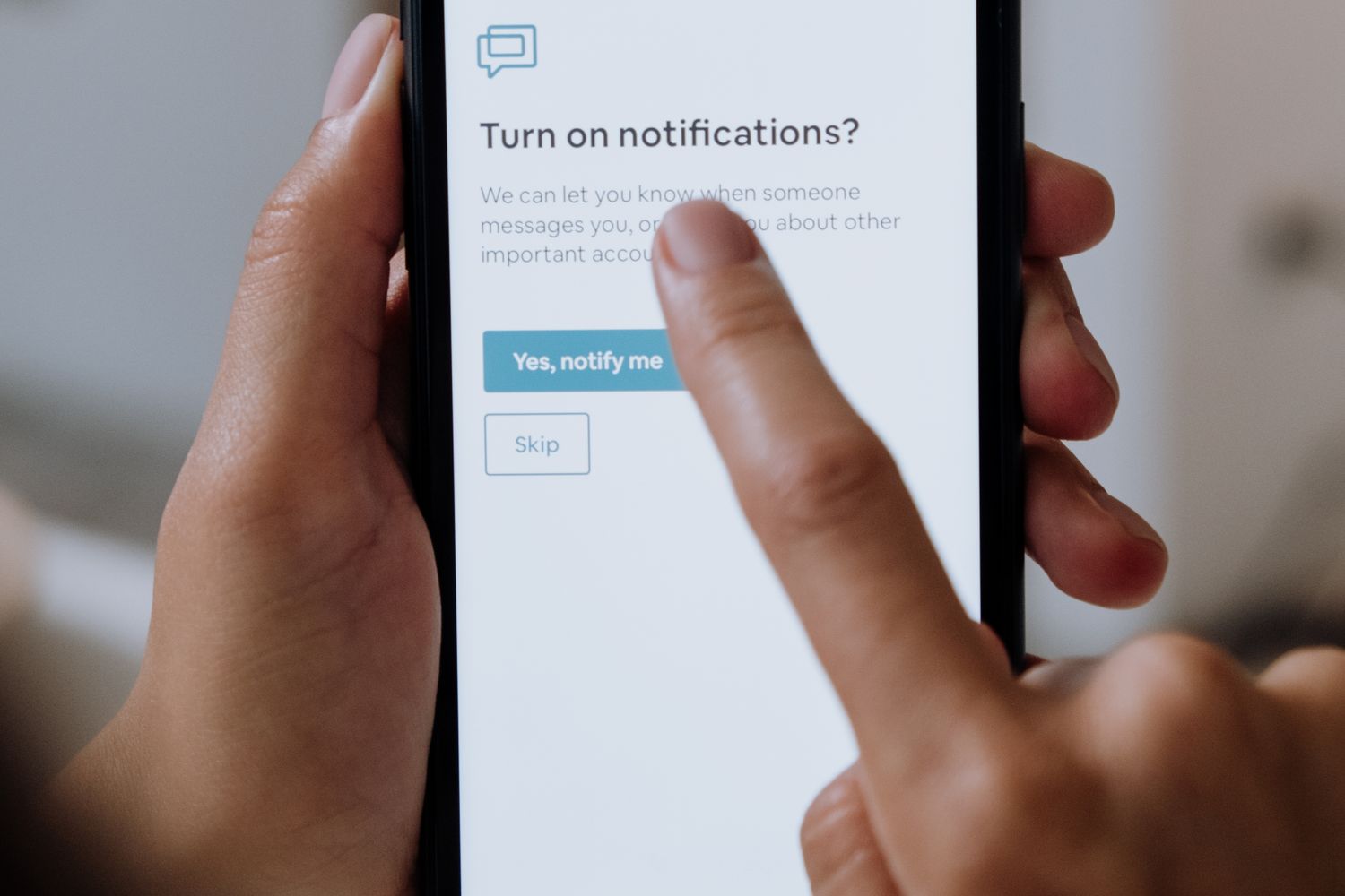 Mãos a utilizar um telemóvel para configurar notificações