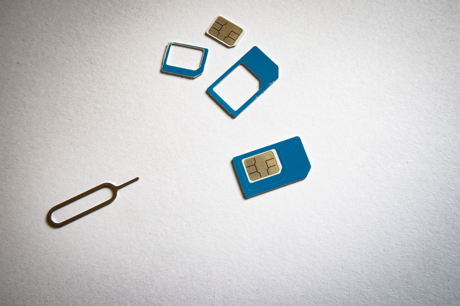 Cartões SIM de vários formatos ao lado da ferramenta de extração do tabuleiro